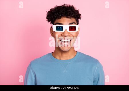 Foto di un bel brunetto ragazzo impressionato orologio film indossare occhiali blue pullover isolato su sfondo color rosa pastello Foto Stock