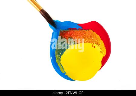 Vernice rossa, gialla e blu con pennello imbevuto Foto Stock