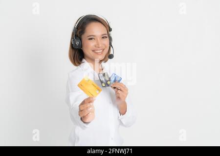 Amichevole helpline femmina o operatore di call center che mostra blank carta di credito, auricolare tenendo le braccia incrociate isolato su sfondo bianco. Foto Stock