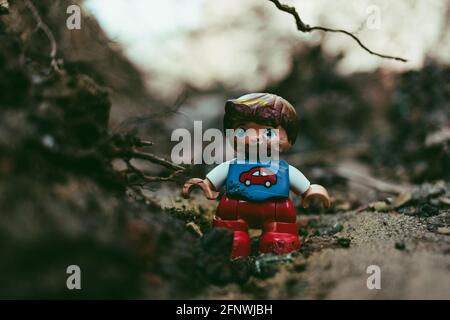 figurina giocattolo del ragazzo danneggiata in rosso e blu con l'auto segno sul petto Foto Stock