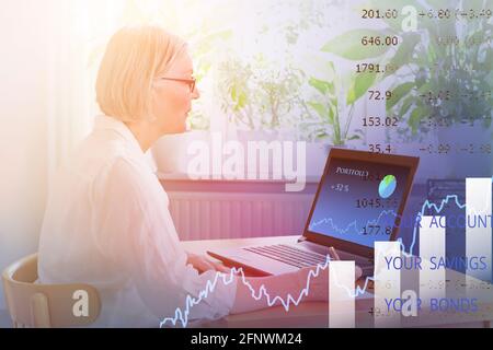 Donna anziana a casa che controlla il suo portafoglio di investimenti sul suo laptop, concetto di online banking, doppia esposizione. Foto Stock