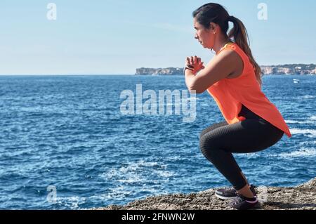 Donna latina, di mezza età, indossando abbigliamento sportivo, allenarsi, fare esercizi fisici, tavola, sit-up, scalino dell'arrampicatore, calorie brucianti, mantenendosi in forma, outdo Foto Stock