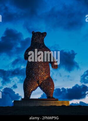 Gigantesca scultura in orso d'acciaio, Dunbear dello scultore Andy Scott, illuminata di notte con un cielo scuro, Dunbar, East Lothian, Scozia, Regno Unito Foto Stock