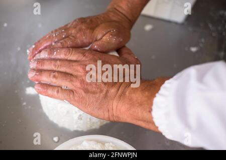 L'uomo inginocchiò il siero della cagliata per fare la ricotta Formaggio in un piccolo caseificio in Italia Foto Stock