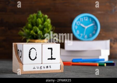 01 agosto. Agosto 01 calendario cubo di legno con oggetti sfocati sullo sfondo. Foto Stock