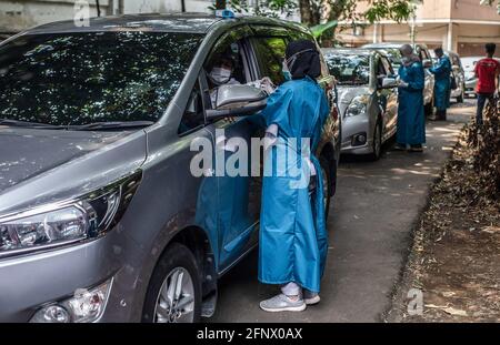 Bogor, Indonesia. 17 Marzo 2021. Un operatore medico somministra una dose di vaccino Sinovac COVID-19 a una donna anziana in un'auto in un sito di vaccinazione drive-thru COVID-19. Il governo indonesiano ha aperto un drive attraverso COVID-19 Servizio di vaccinazione per le persone anziane a Bogor Credit: SOPA Images Limited/Alamy Live News Foto Stock