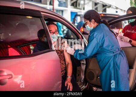 Bogor, Indonesia. 17 Marzo 2021. Un operatore medico somministra una dose di vaccino Sinovac COVID-19 a una donna anziana in un'auto in un sito di vaccinazione drive-thru COVID-19. Il governo indonesiano ha aperto un drive attraverso COVID-19 Servizio di vaccinazione per le persone anziane a Bogor Credit: SOPA Images Limited/Alamy Live News Foto Stock