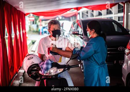 Bogor, Indonesia. 17 Marzo 2021. Un operatore medico somministra una dose di vaccino Sinovac COVID-19 ad un uomo in un sito di vaccinazione drive-thru COVID-19. Il governo indonesiano ha aperto un drive attraverso COVID-19 Servizio di vaccinazione per le persone anziane a Bogor Credit: SOPA Images Limited/Alamy Live News Foto Stock