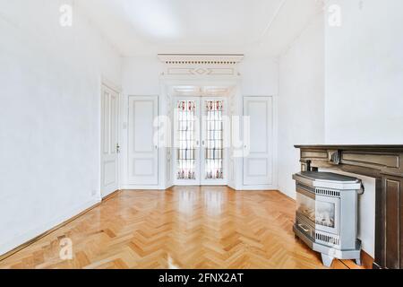 Elegante e lussuoso design interno con porta in vetro di stile vintage e pavimento in parquet arredato con camino Foto Stock