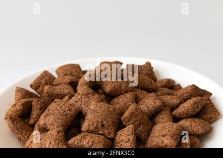 cialde di cioccolato in ciotola isolate su sfondo bianco, cialde di mais al cioccolato, colazione sana, primo piano Foto Stock