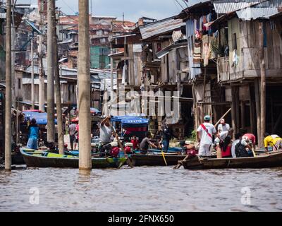 Belen, Perù - dicembre 2019: Persone sulle barche tra case galleggianti nella pianura alluvionale del fiume Itaya, la parte più povera di Iquitos - Belén. Venezia di la Foto Stock