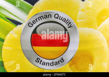 L'iscrizione German Quality Standard sullo sfondo del ananas anelli tagliati closeup Foto Stock