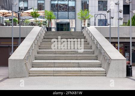 L'entrata al centro affari e' accessibile da una scala grigia di granito con ampi gradini dal marciapiede di ciottoli. Spazio di copia. Foto Stock