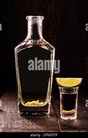 La mezcal (o mescal) è comunemente nota come 'tequila messicana con larva', con larve dell'insetto di gusano sul fondo della bottiglia. Bere con gli alluci Foto Stock