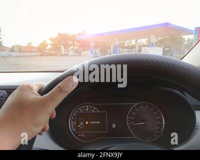 La visualizzazione dell'indicatore di livello basso del carburante nel veicolo causa il conducente per raggiungere la stazione di servizio Foto Stock