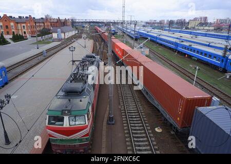Treno per passeggeri parcheggiato nella vista dall'alto della stazione ferroviaria. Locomotiva e treno merci. Foto Stock