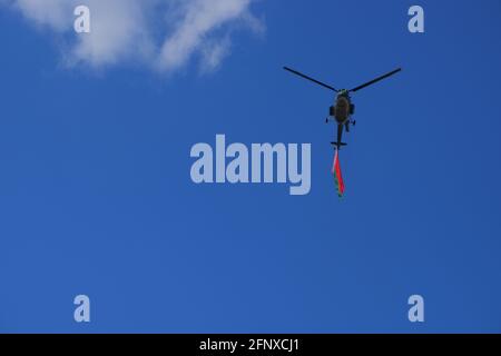 Un elicottero che vola contro un cielo blu con la bandiera bielorussa. Foto Stock