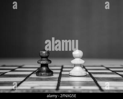 Foto in bianco e nero di due scacchi in piedi sulla scacchiera. Foto Stock
