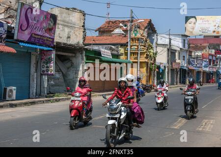 Strada trafficata nel centro di Jaffna con scooter e motociclette che passano davanti a negozi, Provincia del Nord, Sri Lanka Foto Stock