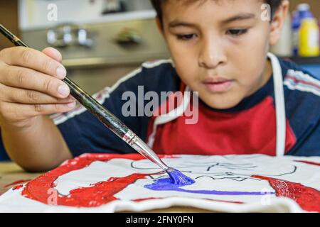 Miami Florida,laboratorio di decorazione tee-shirt del Museo dei Bambini,pittura bambino ragazzo maschio ispanico, Foto Stock