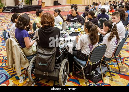 Miami Florida,Drug Free Youth in Town DFYIT Leadership Conference,adolescenti adolescenti studenti ispanici ragazze sala da ballo mangiare mangiare, sedia a rotelle di Foto Stock