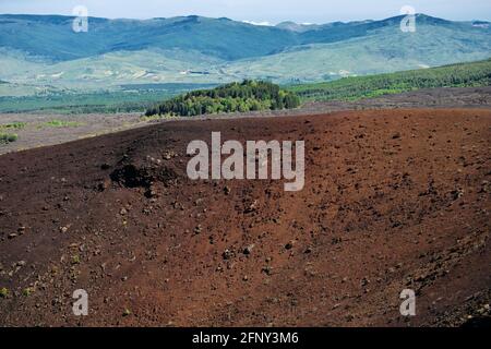 Paesaggio vulcanico in Sicilia bordo di vecchio cratere in Etna Parco sullo sfondo il boscoso Monte Egitto e il Montagne di Nebrodi Foto Stock