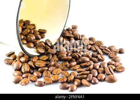 Versare i chicchi di caffè dalle tazze su sfondo bianco Foto Stock