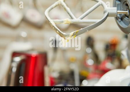 Mescolatore con impasto gocciolante dopo la frusta, fuoco selettivo Foto Stock