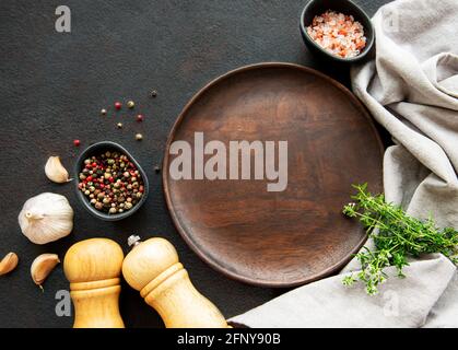 La cottura di utensili in legno, la piastra a vuoto e le spezie. La cottura del cibo concetto di modello. Vista da sopra con copia spazio. Lay piatto Foto Stock