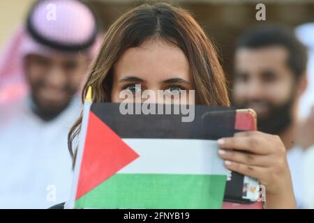 Kuwait, Kuwait. 19 maggio 2021. Una donna che detiene la bandiera della Palestina partecipa ad un rally a Kuwait City, Kuwait, 19 maggio 2021. Centinaia di persone in Kuwait hanno tenuto mercoledì un raduno per sostenere i palestinesi, chiedendo la fine delle violenze nella striscia di Gaza. Credit: Asad/Xinhua/Alamy Live News Foto Stock