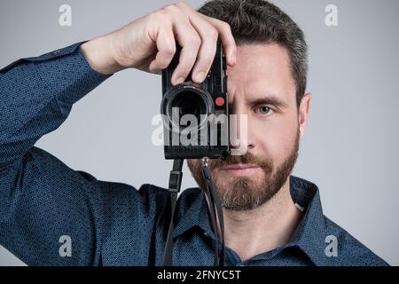 Fotografo di mezza età scatta una foto guardando la fotocamera portatile, l'istantanea. Foto Stock