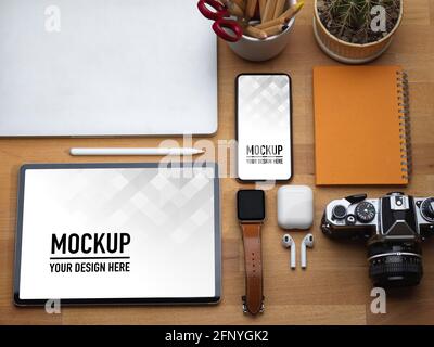 La vista dall'alto del tavolo da lavoro con tablet, smartphone, computer portatile, fotocamera e accessori include il percorso di ritaglio Foto Stock