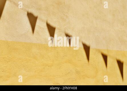 Ombre di bandiere che si accatastano sul muro Foto Stock