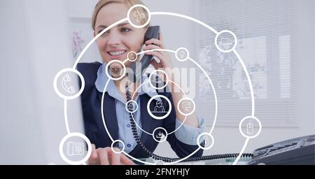 Composizione di reti circolari di icone digitali su uomini d'affari che parlano al telefono Foto Stock