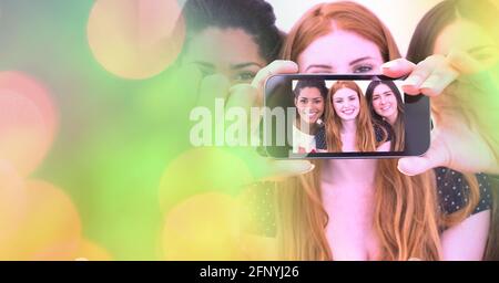 Composizione di cerchi di luce su un gruppo di diverse amiche femminili scattare selfie con lo smartphone Foto Stock