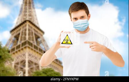 uomo in maschera con cartello di rischio biologico in francia Foto Stock