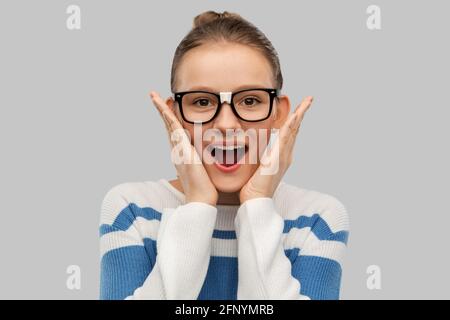 ragazza studentesca sorpresa in occhiali con nastro Foto Stock