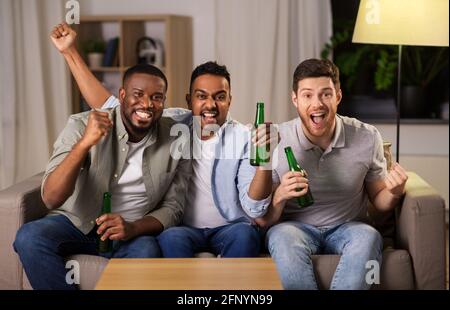 amici maschi felici o fan che bevono birra a casa Foto Stock
