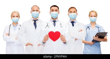 medici in maschere mediche protettive con cuore rosso Foto Stock