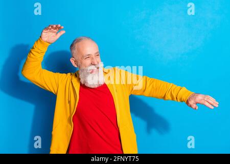 Ritratto fotografico del vecchio uomo che danzava ridendo a guardare la festa copyspace isolato su uno sfondo di colore blu intenso Foto Stock