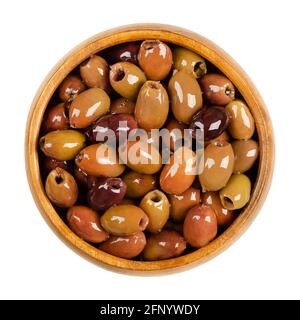 Olive Leccino snocciolate, conservate in olio d'oliva, in una ciotola di legno. Leccino, una delle principali cultivar d'oliva per la produzione italiana di olio d'oliva. Foto Stock