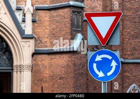 il segno è movimento circolare e lasciare il posto sullo sfondo dell'edificio, primo piano Foto Stock