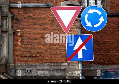 il segno è movimento circolare, dare il passo e la fine di una strada a senso unico sullo sfondo urbano, primo piano Foto Stock