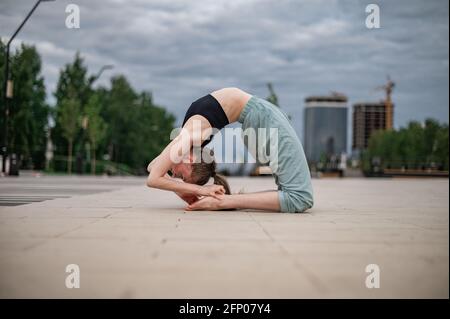 La ragazza pratica yoga e meditazione in città. Foto Stock