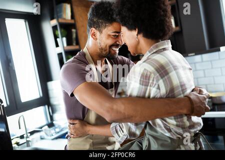Bella coppia sono abbraccianti e sorridenti mentre passare il tempo in cucina Foto Stock