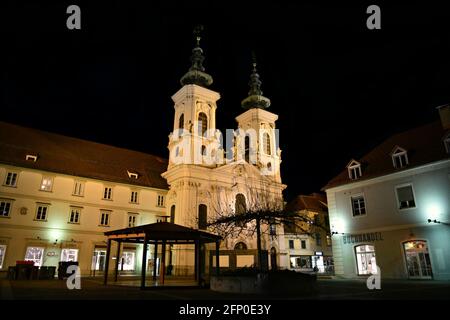 Panoramica nocturne vista di Mariahilferkirche, una chiesa in stile barocco del 13 ° secolo su Mariahilfestrasse a Graz, capitale della Stiria, Austria. Foto Stock