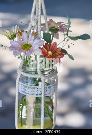 decorazioni rustiche per un matrimonio con margherite color pastello e. foglie di eucalipto in vasi di vetro Foto Stock