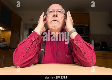 Uomo con le dita nelle orecchie le orecchie, non disposto ad ascoltare o ad ascoltare Foto Stock