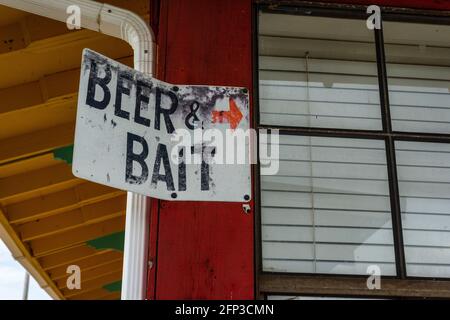 Un vecchio cartello sul molo municipale di Fairhope indica la strada per la birra e l'esca a Fairhope, Alabama, il 19 maggio 2021. Foto Stock