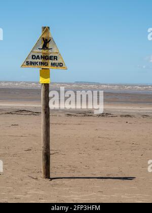 Un segnale di avvertimento sul pericolo di affondamento di fango, a bassa marea, sulla spiaggia di Sand Bay, vicino a Weston-super-Mare, nel Somerset del Nord Foto Stock